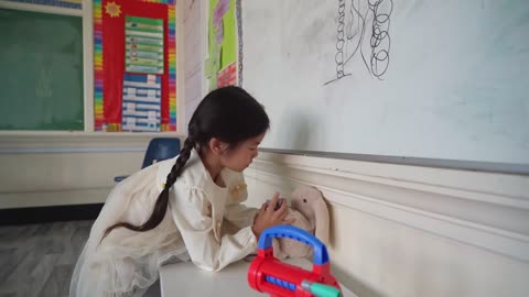 a little boy playing with a very pretty bunny doll