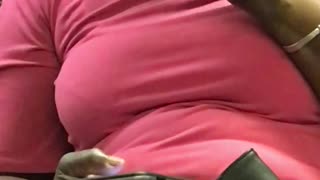 Woman in pink flossing her teeth on train