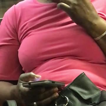 Woman in pink flossing her teeth on train