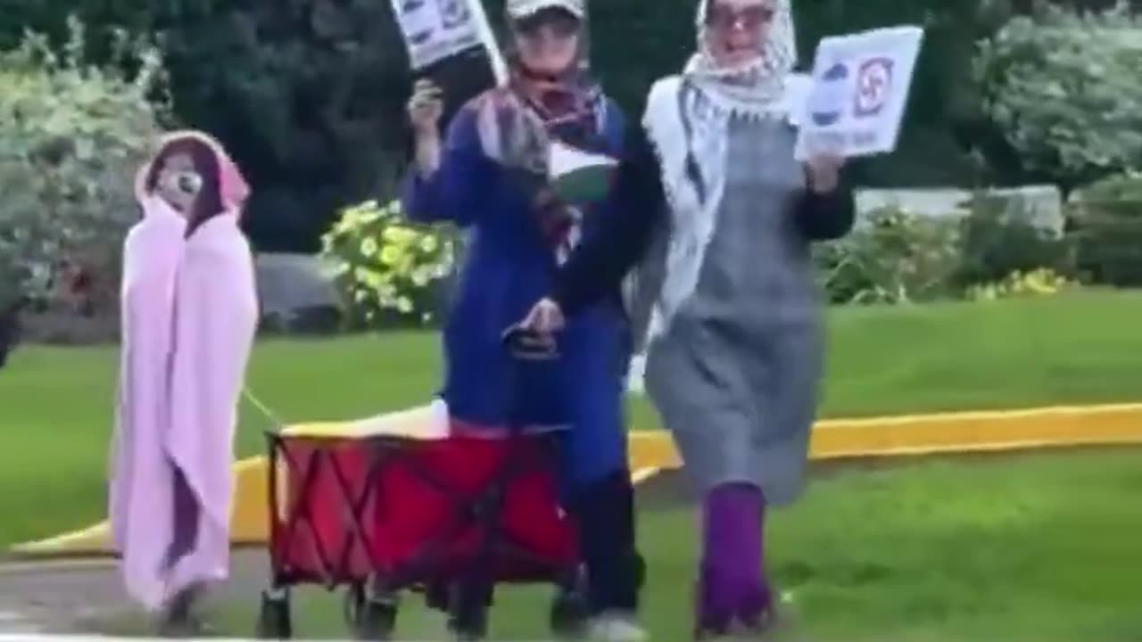 Muslim mothers walk their children through a Jewish neighborhood in Toronto carrying Swastikas. - Islam / Islamic Hate