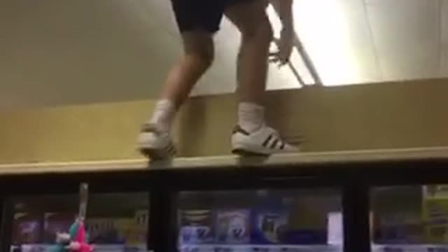 Man walks on top grocery fridge