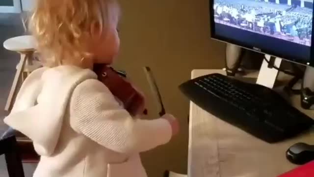Little cute child watching TV and trying to play guitar🎸 hero
