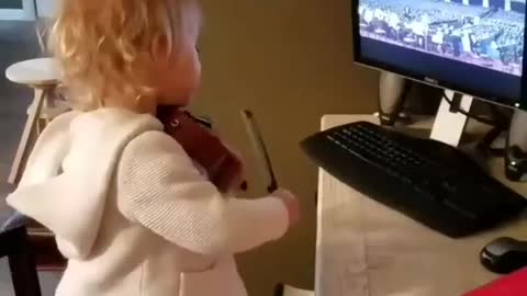 Little cute child watching TV and trying to play guitar🎸 hero