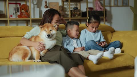 A Mother Relaxing In The Sofa With Her Kids