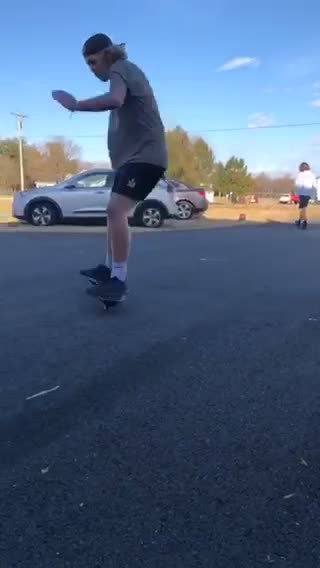 Backwards hat short shorts kid rides ripstick driveway