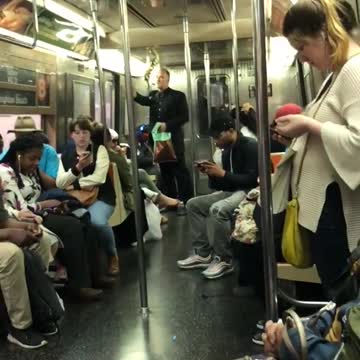 Guy in black dress shirt standing subway gold string being sucked into air conditioning vent