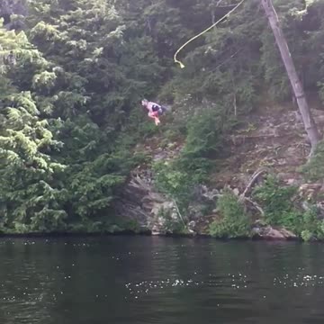 Guy does a front flip and belly flops in a lake from a ropeswing