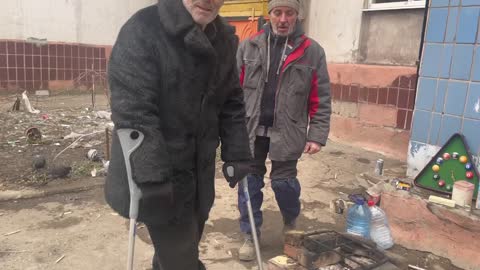 Mariupol, people are warming themselves at their campfires