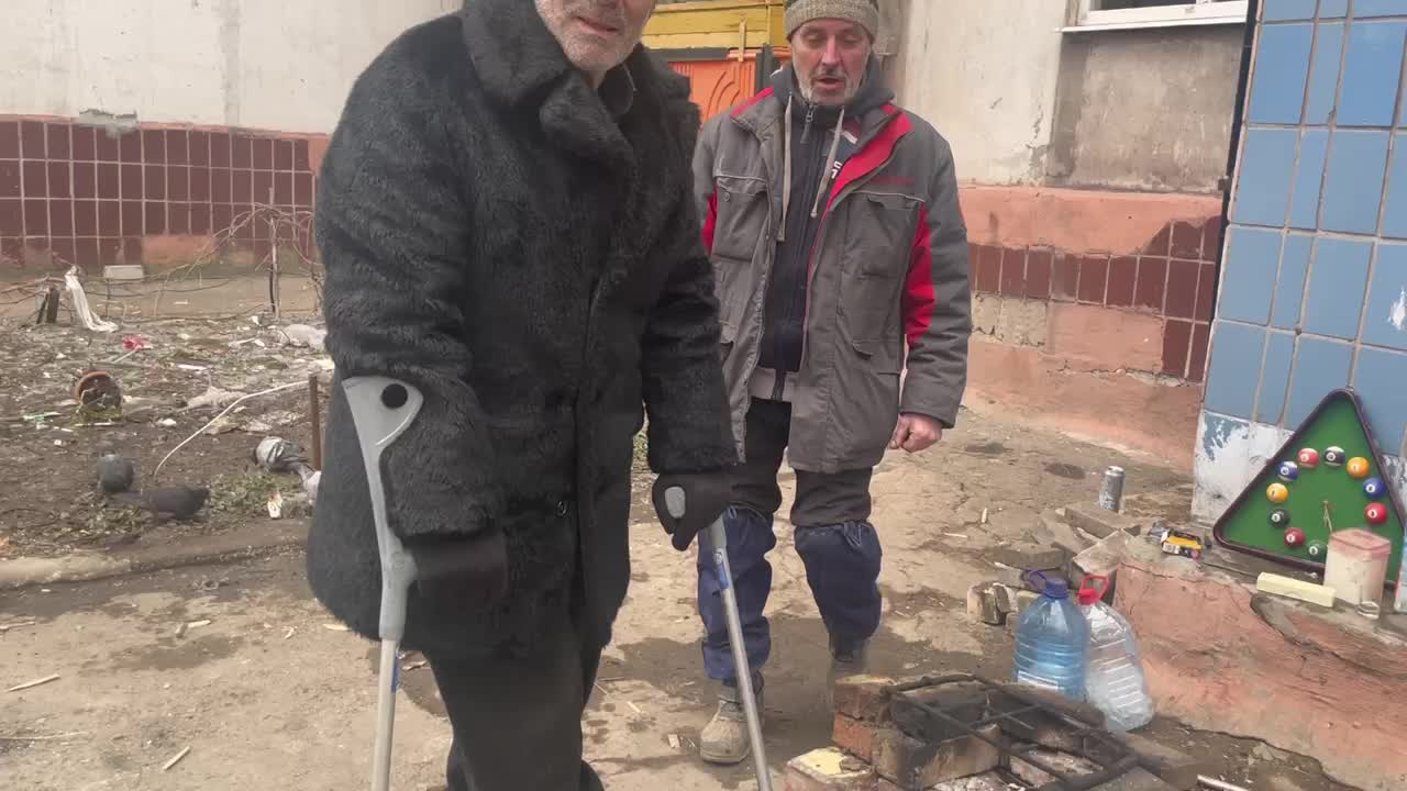 Mariupol, people are warming themselves at their campfires