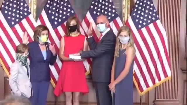 Nancy Pelosi takes off mask, breaking her own mandate, for a photo.