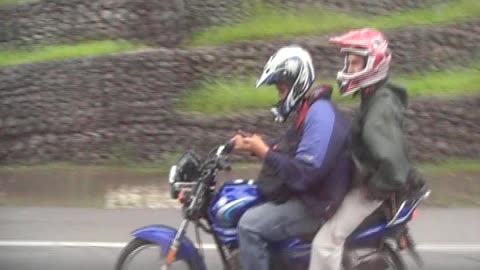 Motorcycle rider drives and texts with rider on back