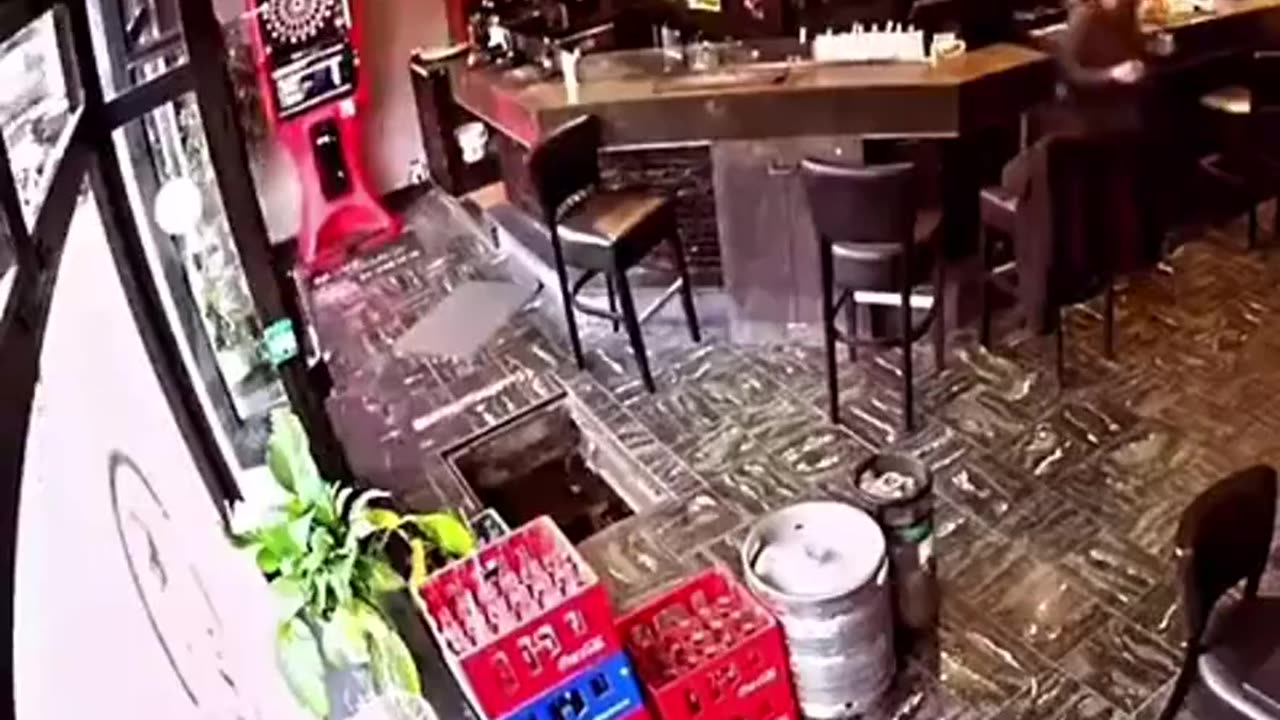 Woman falls down a hole while entering a cafe