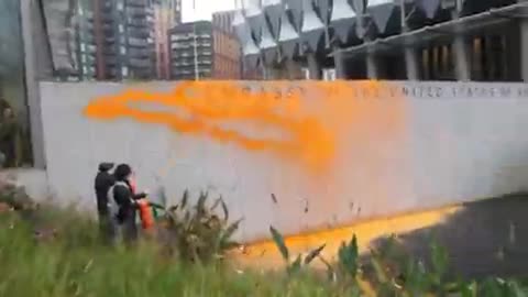 Environmental activists target U.S. embassy in London with orange paint following election