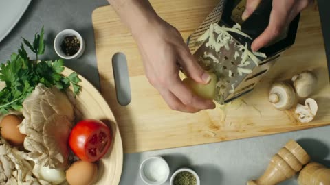 Person Grating A Potato