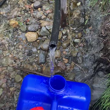 ICE COLD SPRING WATER ON BANK OF REMOTE ALASKA RIVER