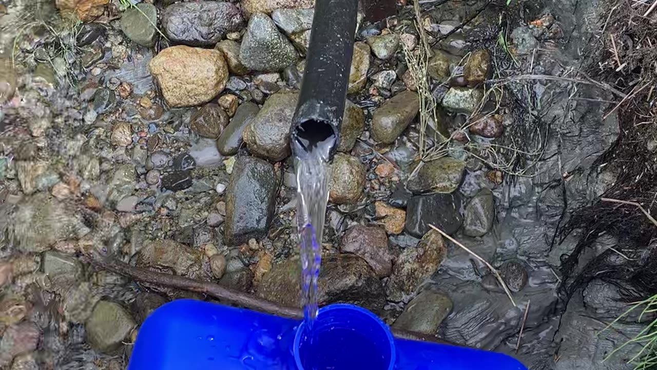 ICE COLD SPRING WATER ON BANK OF REMOTE ALASKA RIVER