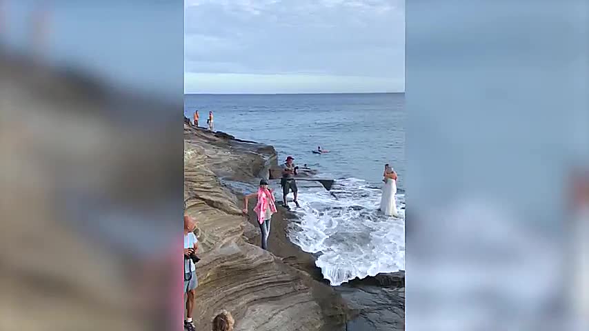 Couple Gets Wiped out by Wave During Wedding Photo Shoot