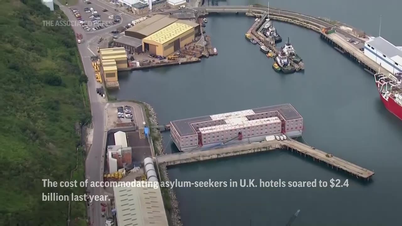 UK moves first migrants onto giant barge