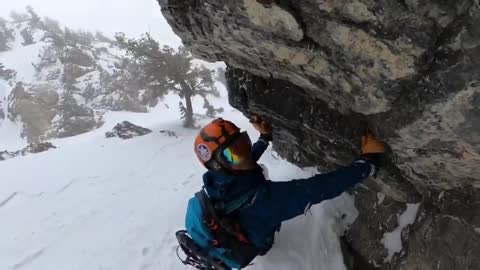 Man uses rockface to avoid avalanche.