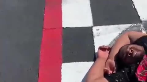 Man Tries to Beat Car to Finish Line While It Goes Around Circuit