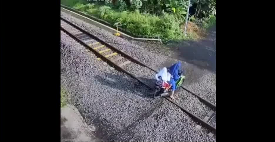 The girls on the moped got up, on the rails