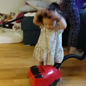 Baby girl figure out vacuum cleaner for the first time