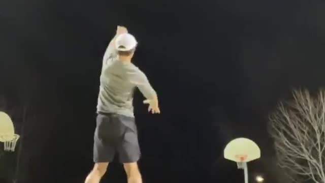 Guy Makes Impressive Basketball Trickshot From Half Court While Balancing on Two Balls
