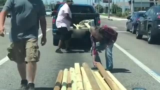 Strangers Help Old Man Load Timber Fallen on the Road Into his Pickup Truck