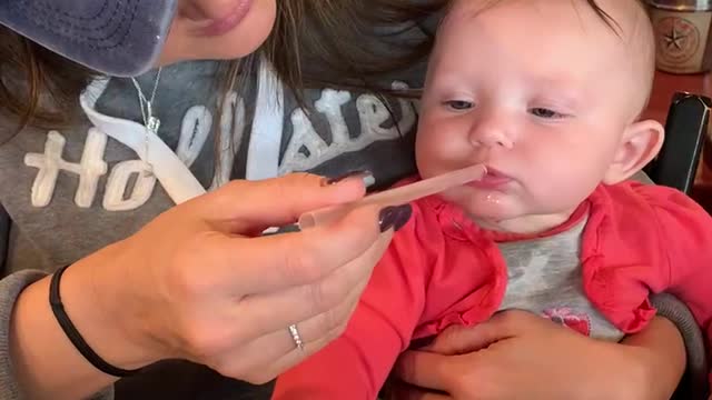 Baby learning to drink from a straw.