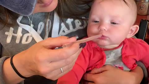 Baby learning to drink from a straw.