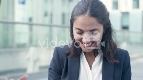 Happy Female Employee Discussing Job Success With Colleague Outside And Giving Her High Five