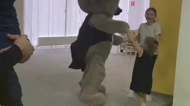 video dancing of a bear and children on the playground