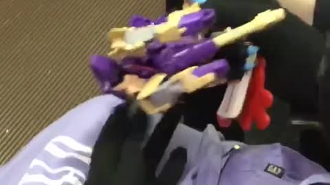 Person playing with purple lego toy on train