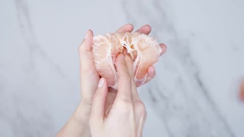 Feeling The Gap On A Peeled Grapefruit Using A Finger