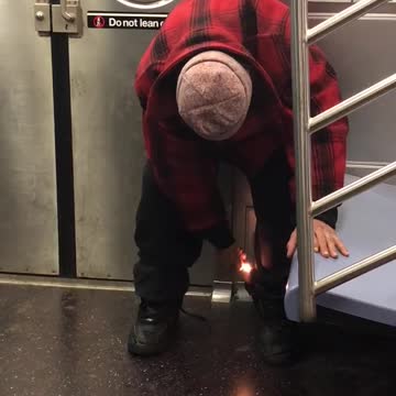 Plaid shirt man tries to light black pants on fire on subway