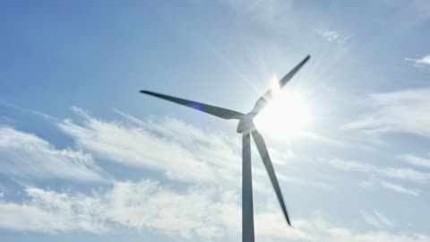 Bright sunshine behind a wind turbine