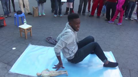 Luodong Massages Black Man On Sidewalk In Front Of Crowd