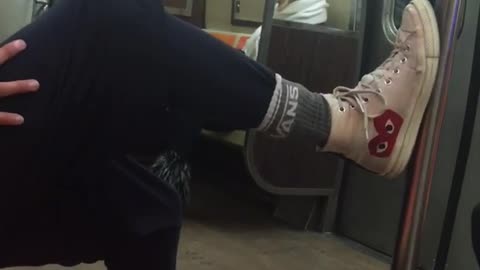 Man with foot on subway pole