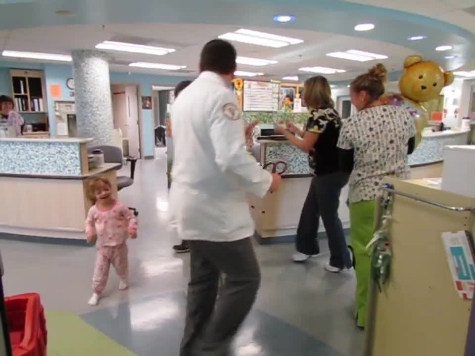 Doctors and nurses dance with sick child