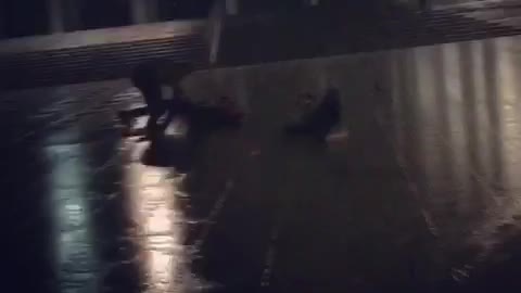 Guys running in rain slip and fall down