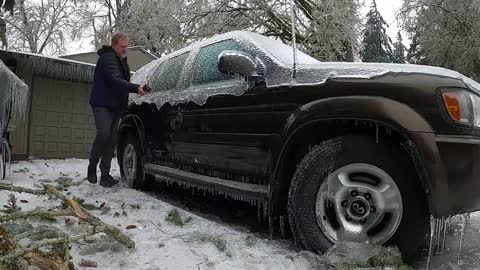 Freeing my Truck of thick ice from last night's storm using a rubber mallet.