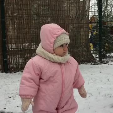 Beba super emocionada de estar fuera en una tormenta de nieve