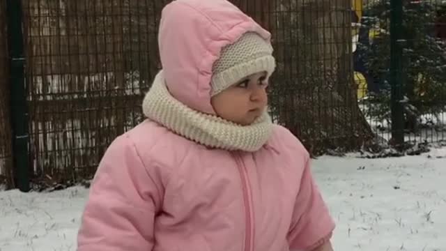 Beba super emocionada de estar fuera en una tormenta de nieve