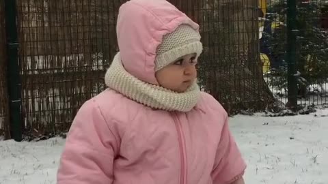 Beba super emocionada de estar fuera en una tormenta de nieve