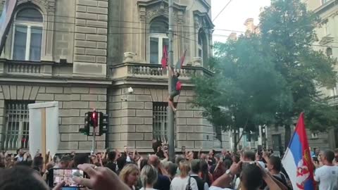 Serbia: man climbs up light post and hangs Christ flag