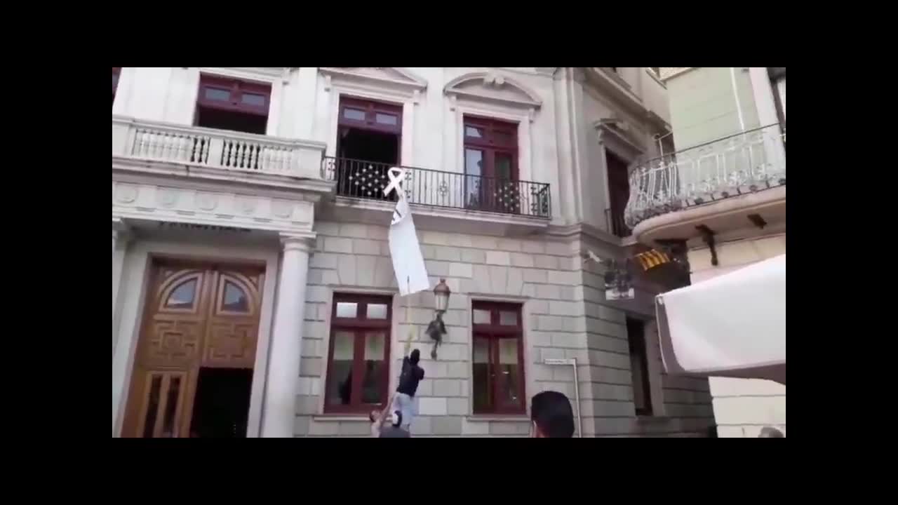 Los catalanes tumban la pancarta de presos separatistas en la fachada del Ayuntamiento de Reus