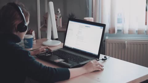 Young girl with short hair working on a laptop