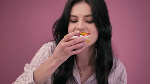 Girl eating a glazed donut with a milkshake