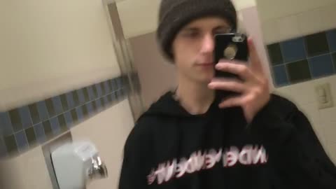 Guy green beanie runs into wall in bathroom