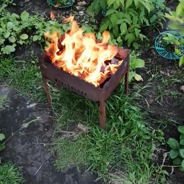 A fire burns in the daytime.